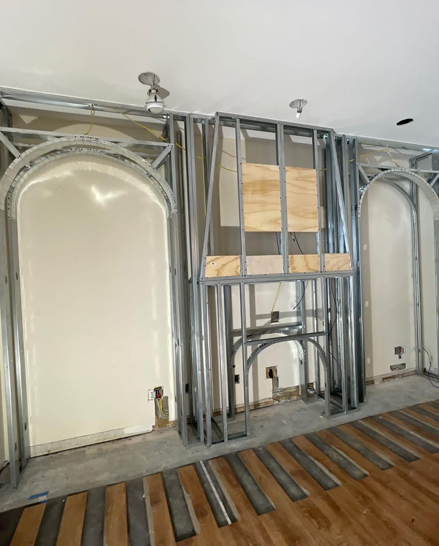 Steel framing with custom archways before drywall installation